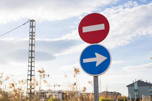 Blue road sign with white arrow to the right and no entry sign.