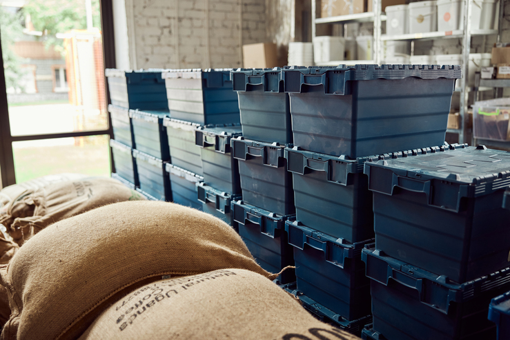 Coffee warehouse with burlap sacks and blue plastic boxes with lids